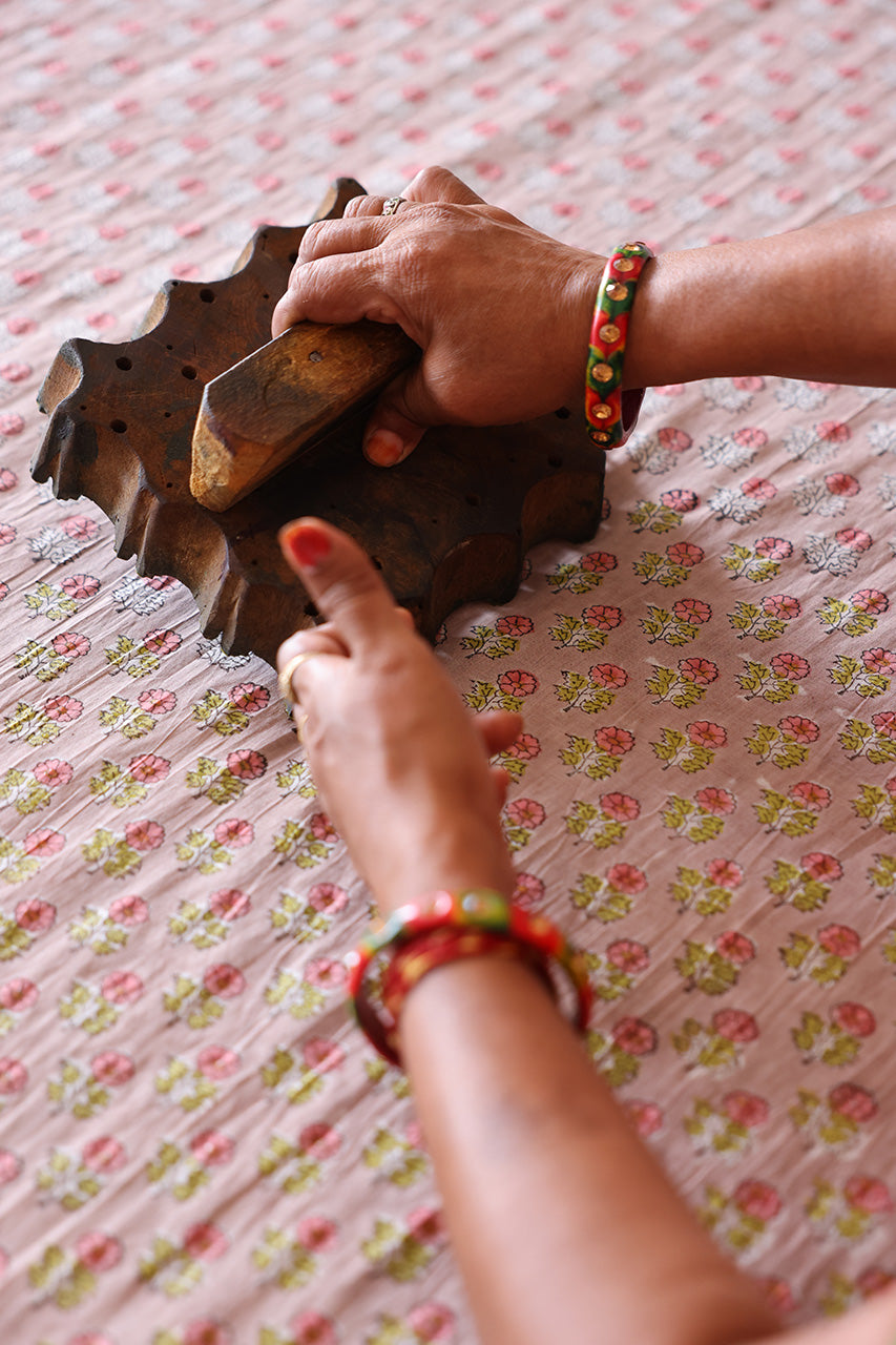 Jaipur artisan hand block printing floral pattern on cotton fabric — traditional craft behind Daughters of India