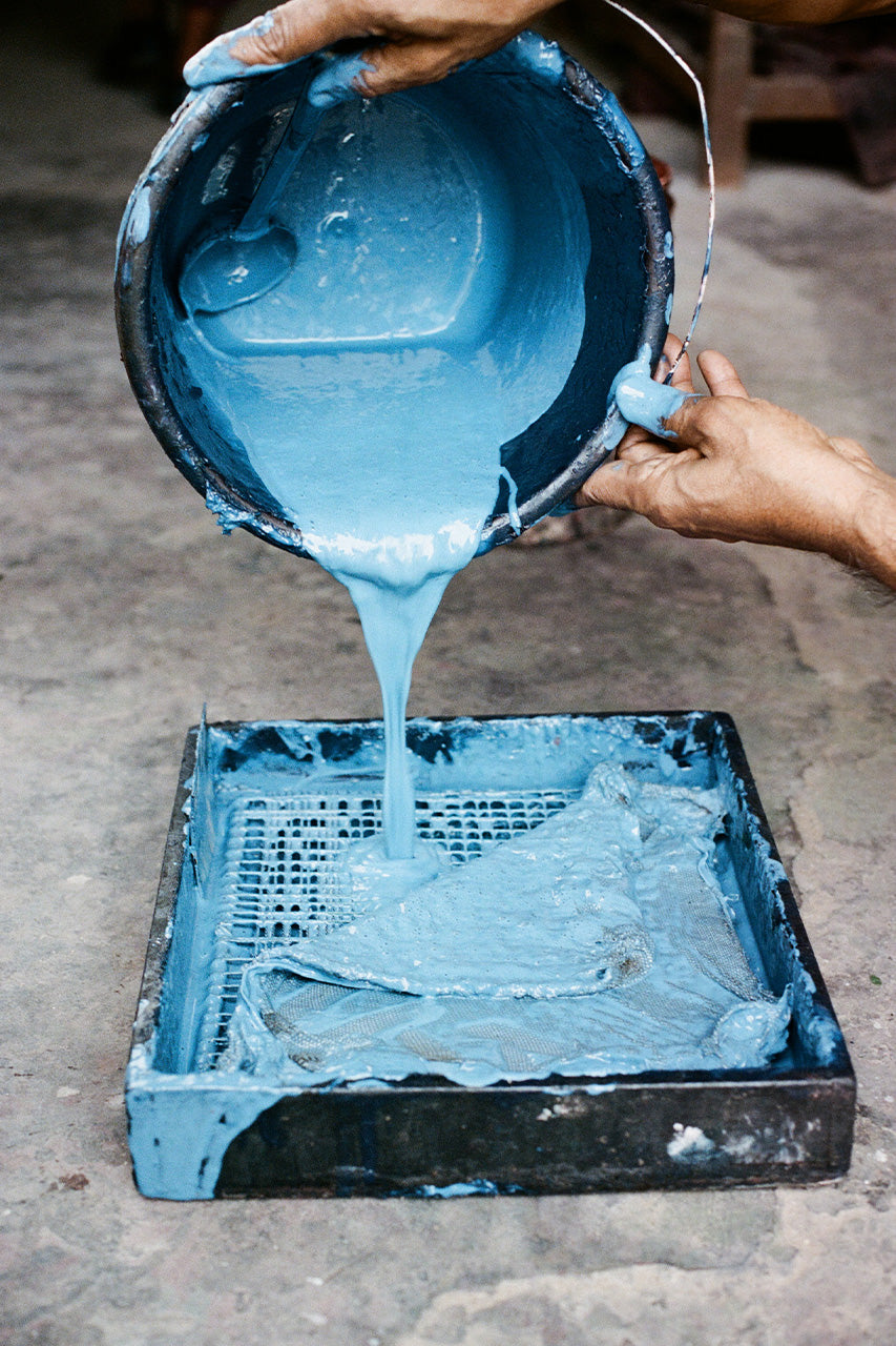 Daughters of India — artisan pouring ocean blue screen print dye into tray for hand screen printing